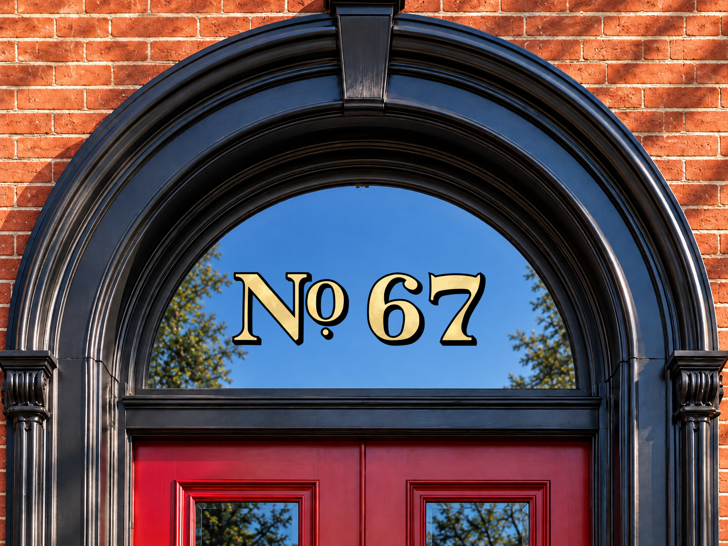 Smaller Baltimore No. 67 house numbers with a subtle gold shimmer and black shadow in an arched transom above red doors